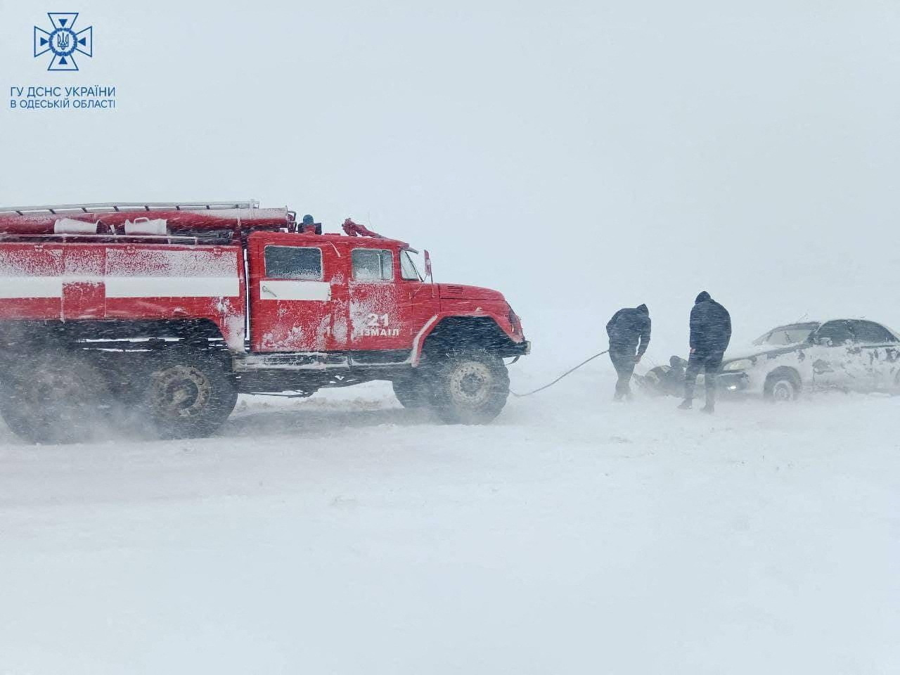 Emergency workers release a car which is stuck in snow during a heavy snow storm in Odesa region