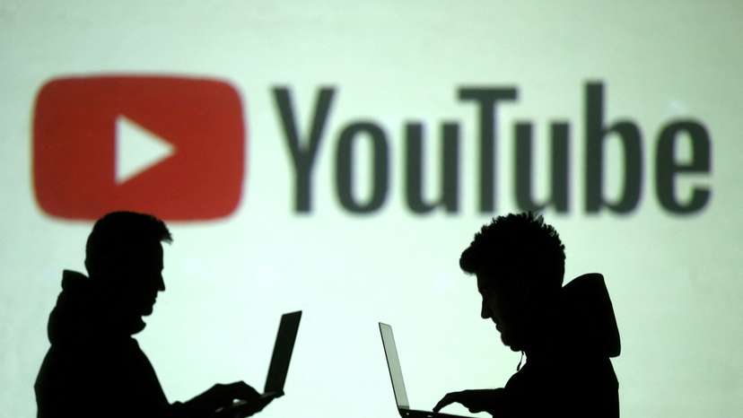 FILE PHOTO: Silhouettes of mobile device users are seen next to a screen projection of Youtube logo in this picture illustration