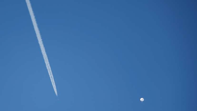 A jet flies by a suspected Chinese spy balloon as it floats off the coast in Surfside Beach