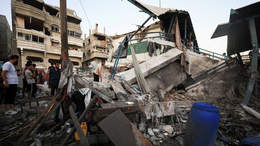Palestinians gather at a UN school sheltering displaced people, following an Israeli strike, amid Israel-Hamas conflict, in Gaza City