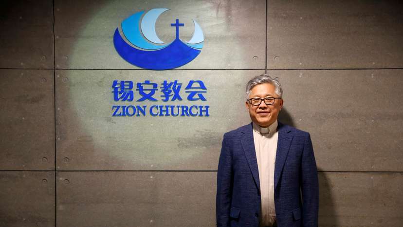 FILE PHOTO: The head pastor of the Zion church in Beijing Jin Mingri poses for picures in the lobby of the unofficial Protestant "house" church in Beijing