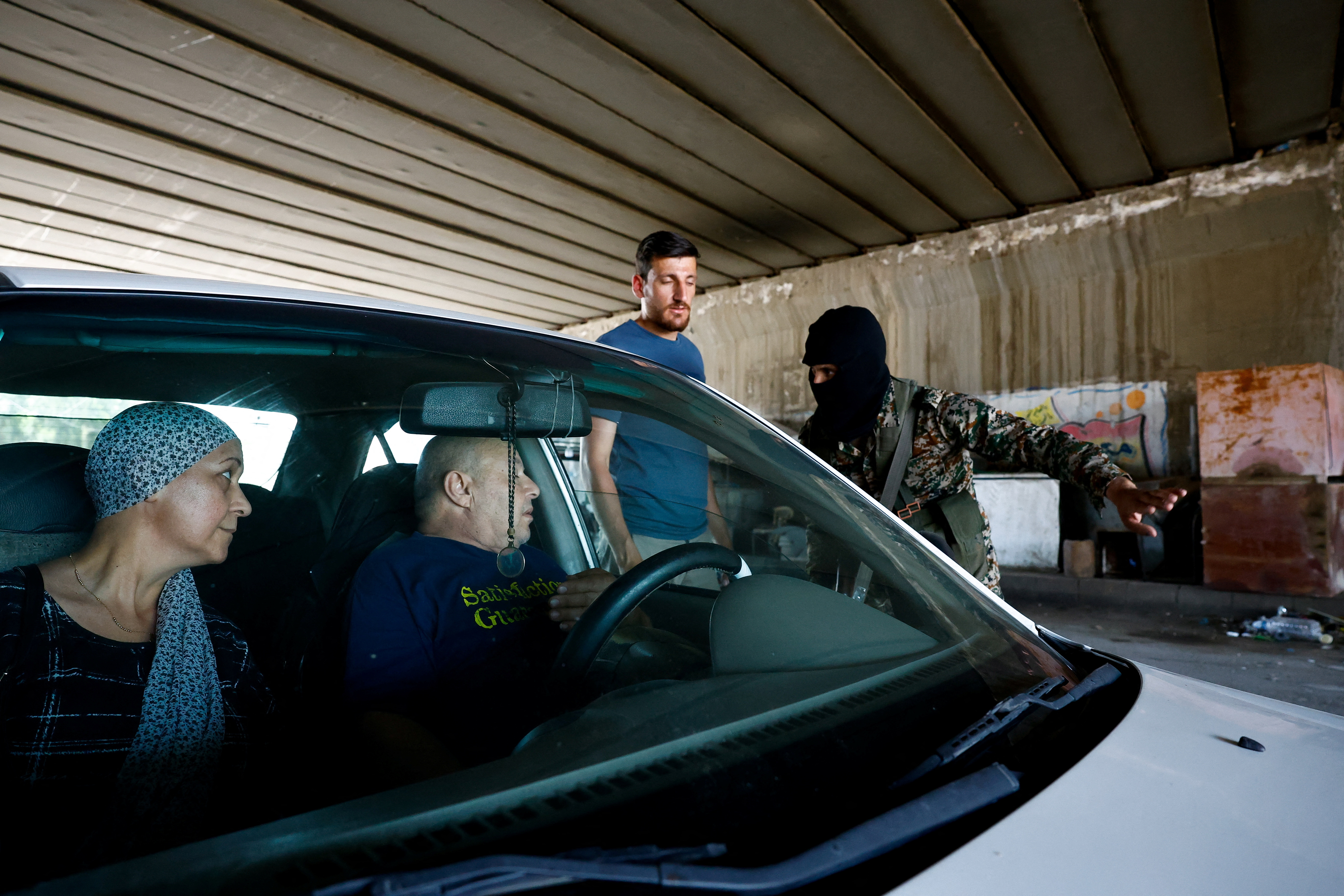 Syrian security forces check vehicles at the entrance of Druze town of Jaramana