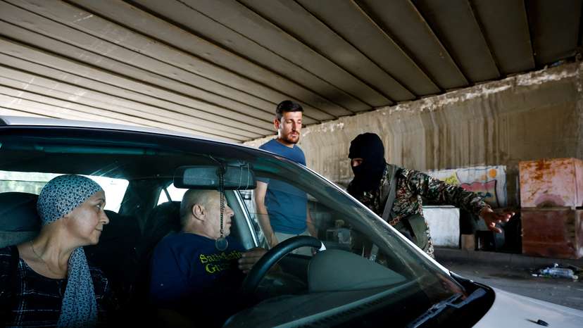 Syrian security forces check vehicles at the entrance of Druze town of Jaramana