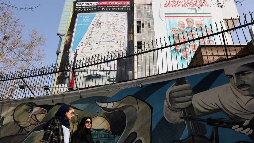 Iranian women walk past an anti-Israeli billboard in Tehran