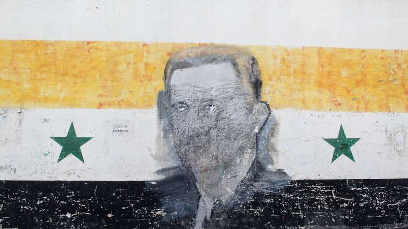 A wall painted with a damaged drawing of ousted Syrian President Bashar al-Assad is pictured in the al-Qadam neighbourhood' in Damascus