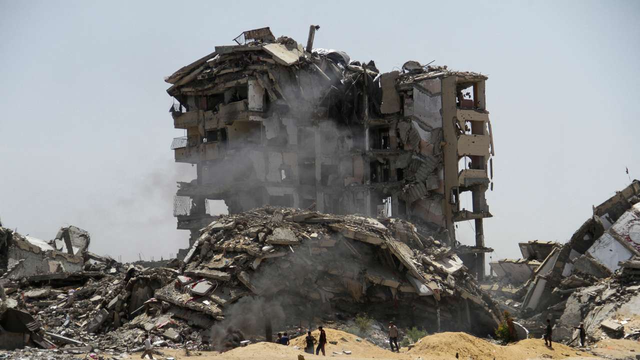 Palestinians walk past the rubble of residential buildings destroyed by Israeli strikes, amid the ongoing conflict between Israel and Hamas, in the northern Gaza Strip