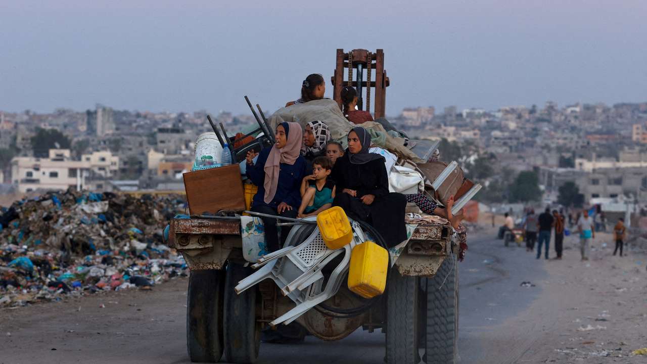 Displaced Palestinians make their way after fleeing the western part of Khan Younis, following an evacuation order by the Israeli army