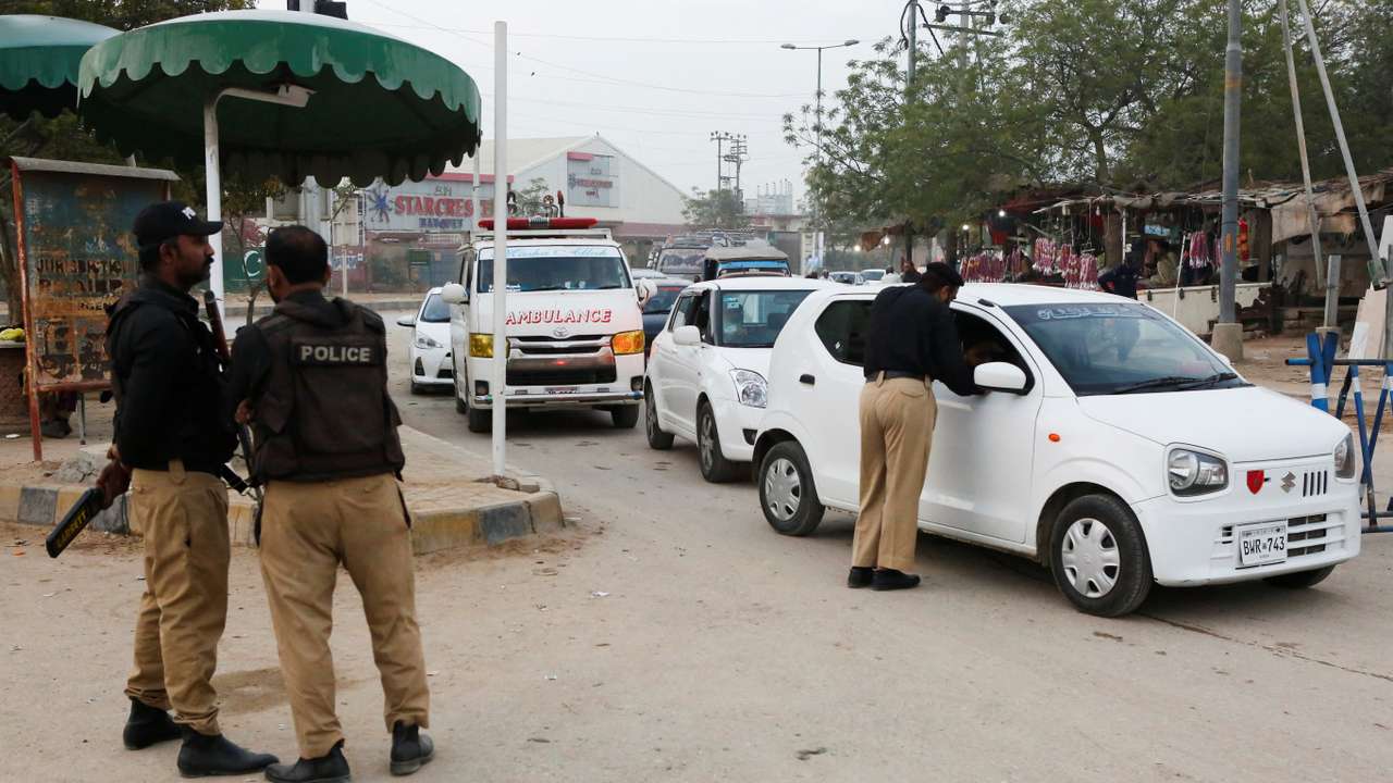 Police officers check vehicles as a security measure, following exchanges of fire between Pakistani and Afghan forces, along a road leading to the airport in Karachi