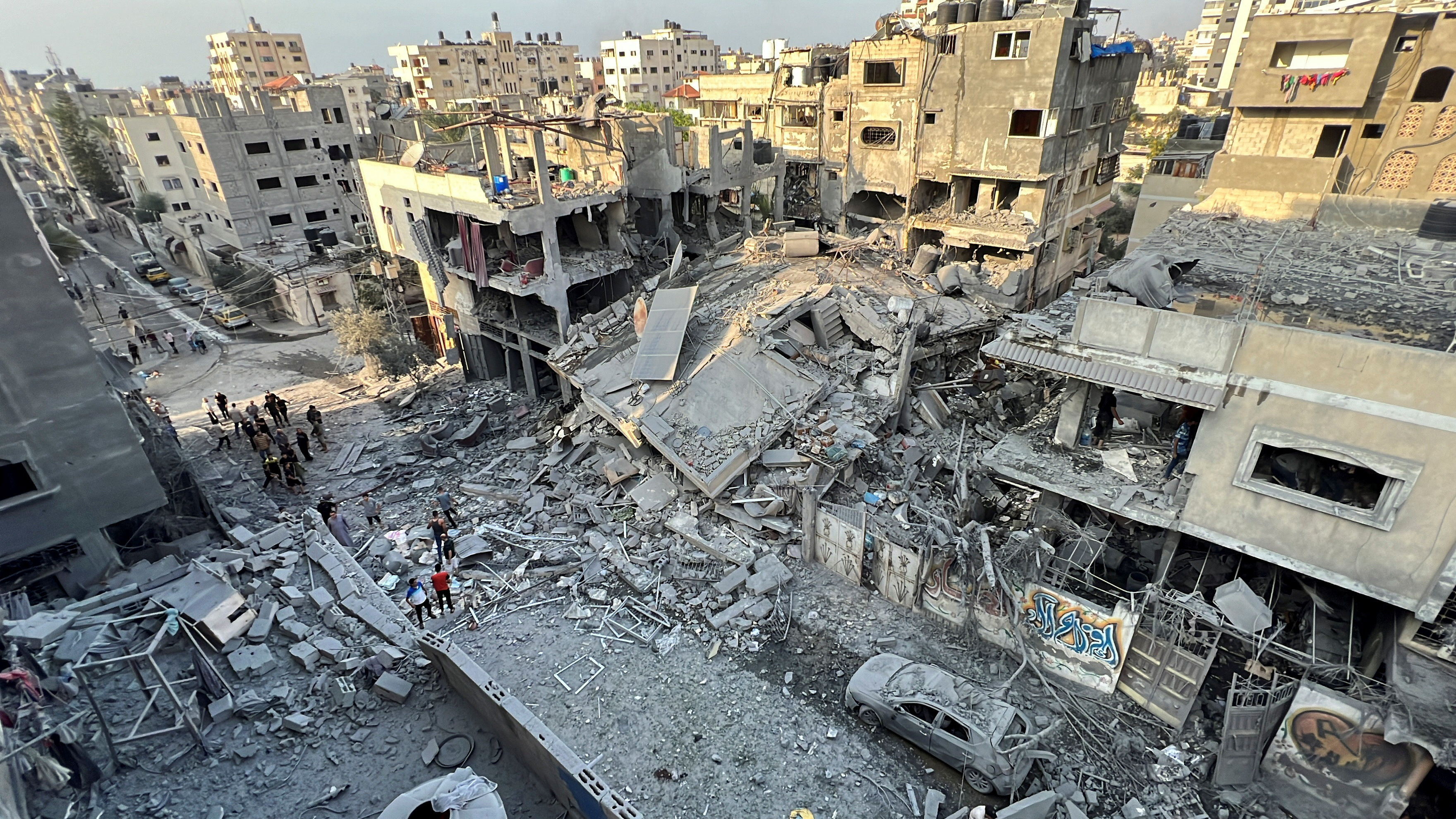 Palestinians search for casualties at the site of Israeli strikes on houses, in Gaza City