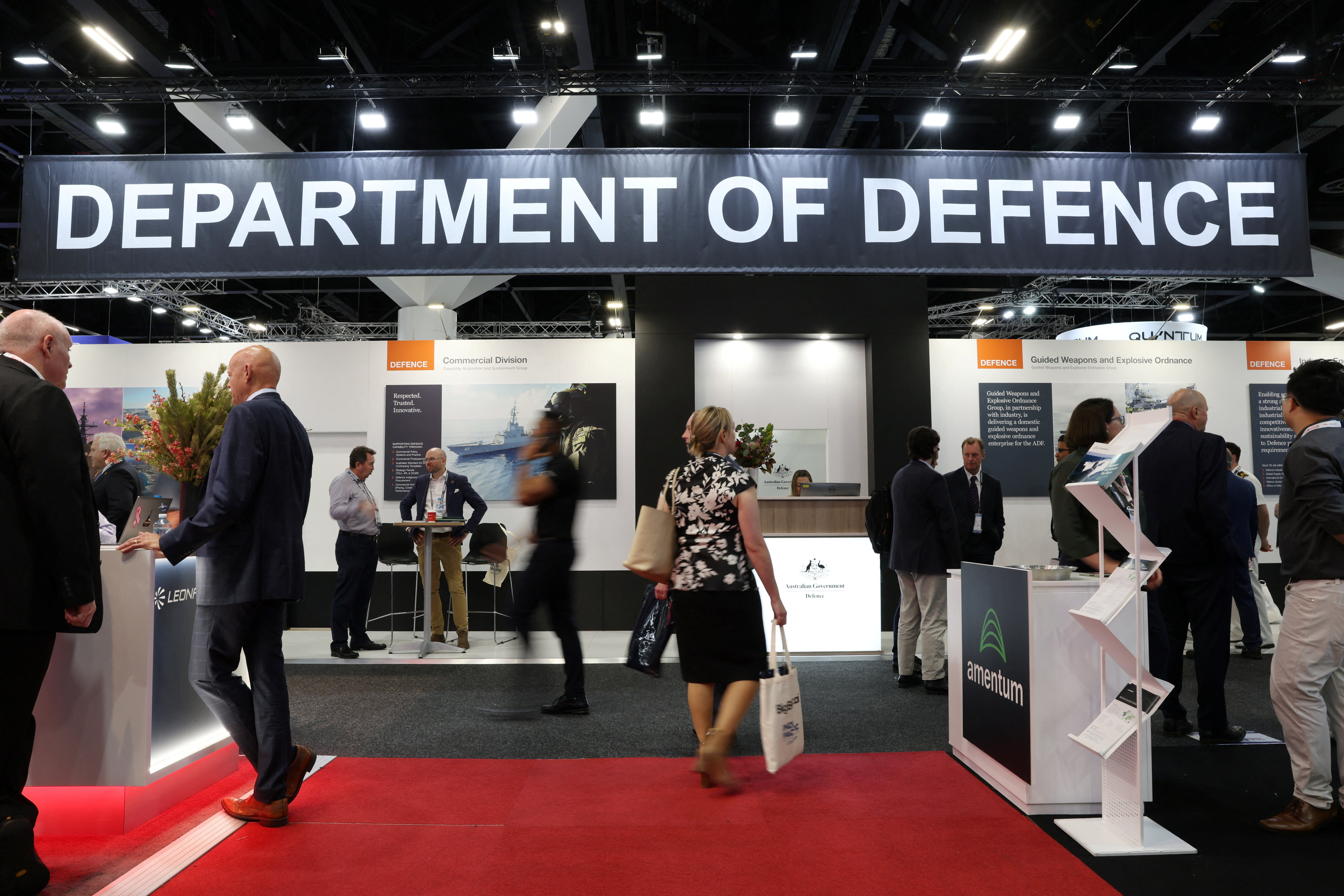 People walk past the Australian Government's Department of Defence stand at the Indo Pacific International Maritime Exposition in Sydney