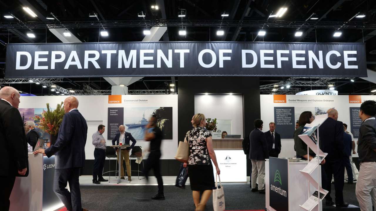 People walk past the Australian Government's Department of Defence stand at the Indo Pacific International Maritime Exposition in Sydney