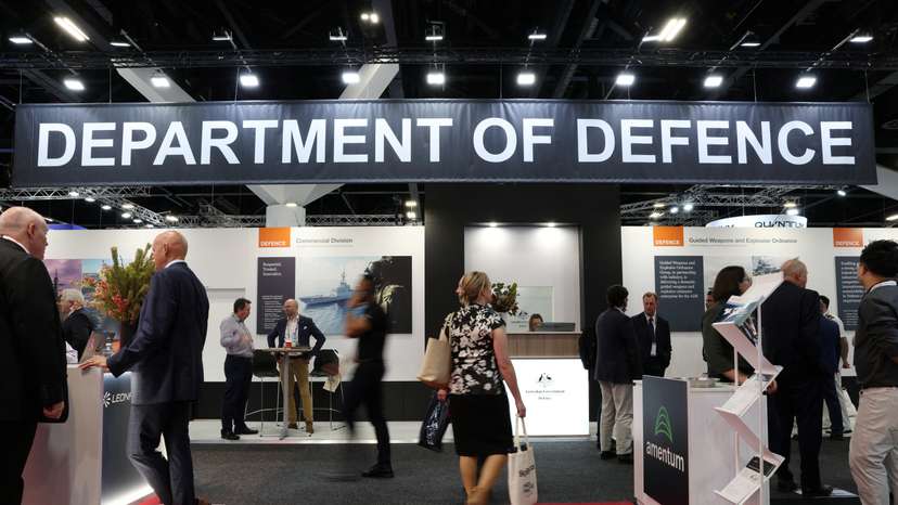 People walk past the Australian Government's Department of Defence stand at the Indo Pacific International Maritime Exposition in Sydney
