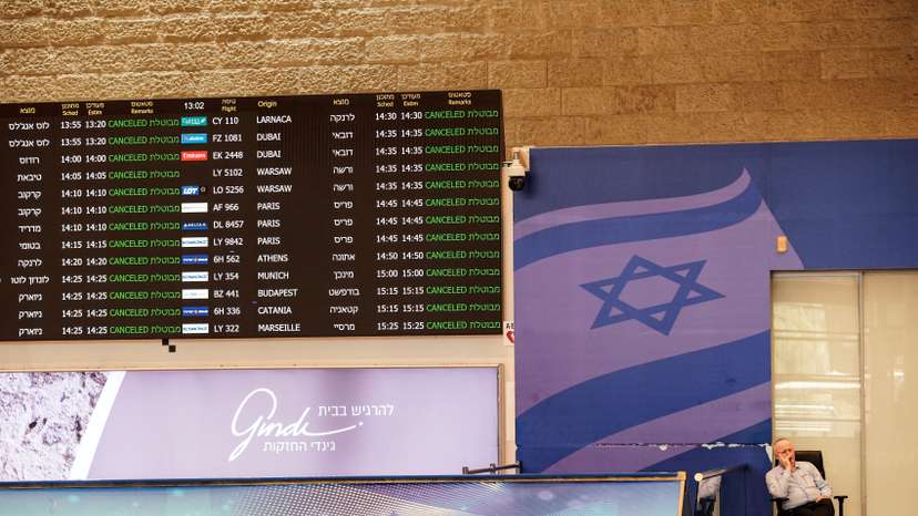 A staff of Ben Gurion International Airport, sits at the arrivals terminal as all flights from and to the airport are indicated cancel, following Israel's attack in Iran last night in Lod near Tel Aviv