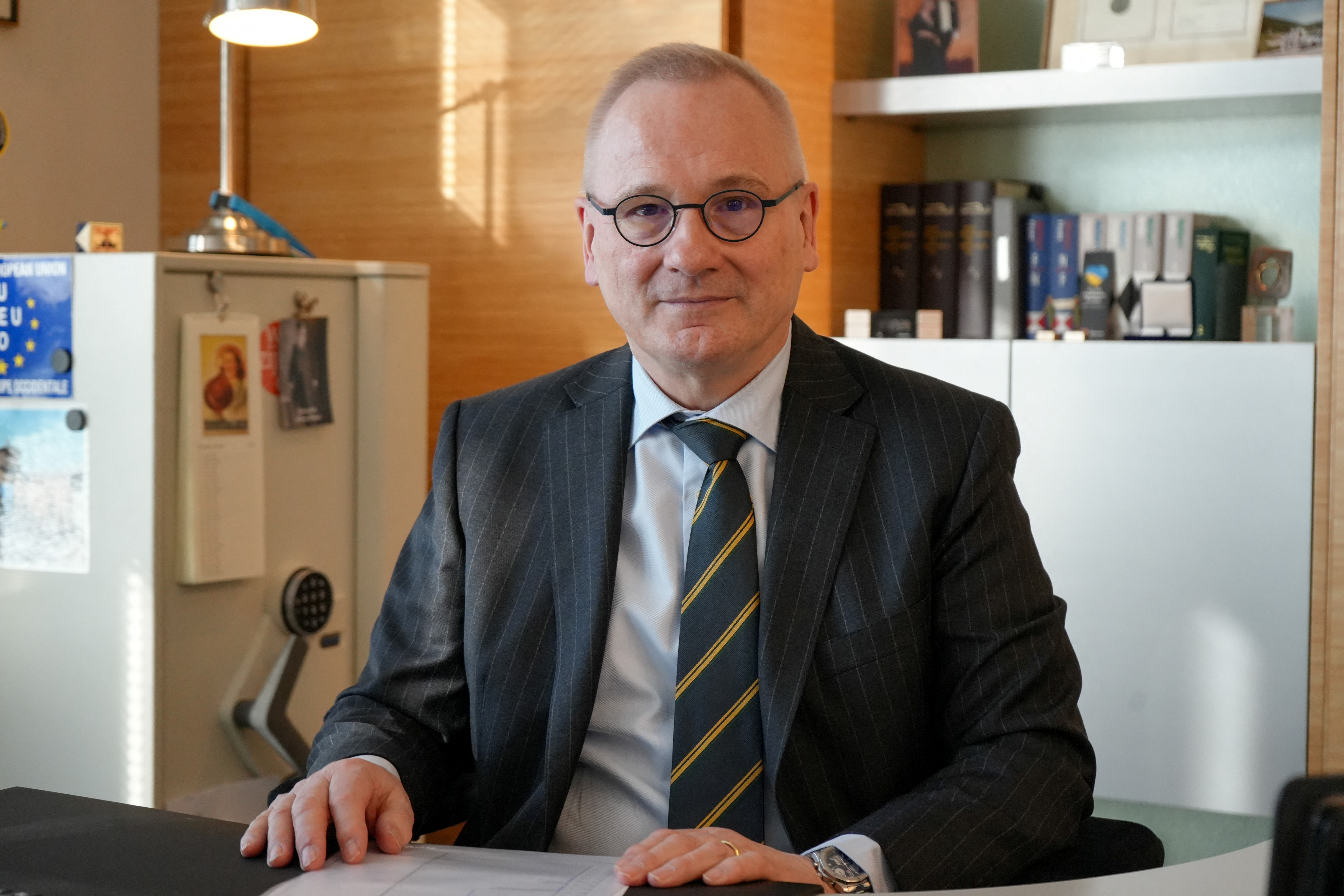 Robert in den Bosch sits at a desk in his office in Geneva