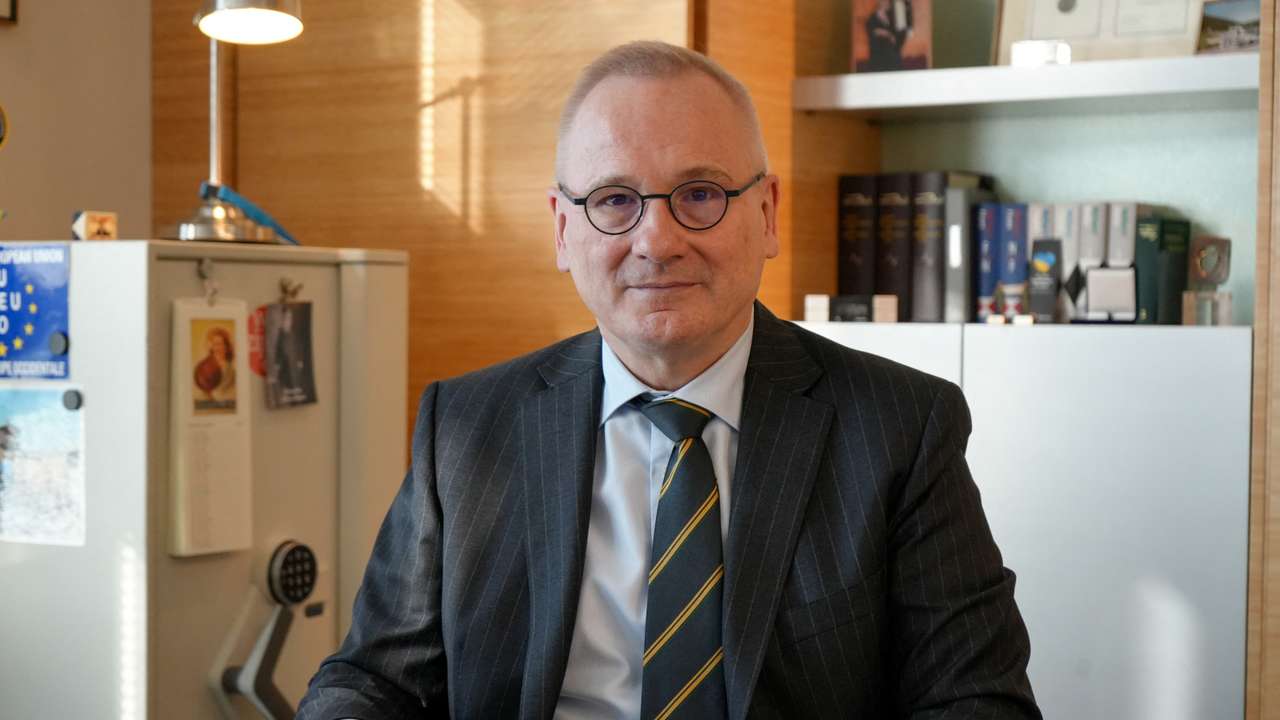 Robert in den Bosch sits at a desk in his office in Geneva