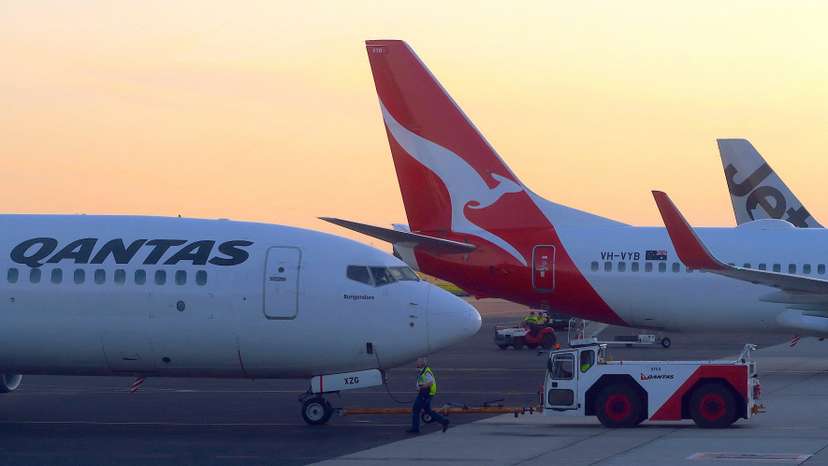 FILE PHOTO: Workers are seen near Qantas Airways, Australia's national carrier, Boeing 737-800 aircraft on the tarmac at Adelaide Airport