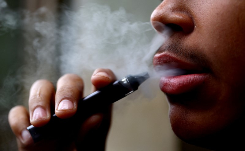 FILE PHOTO: A man smokes a disposable vape