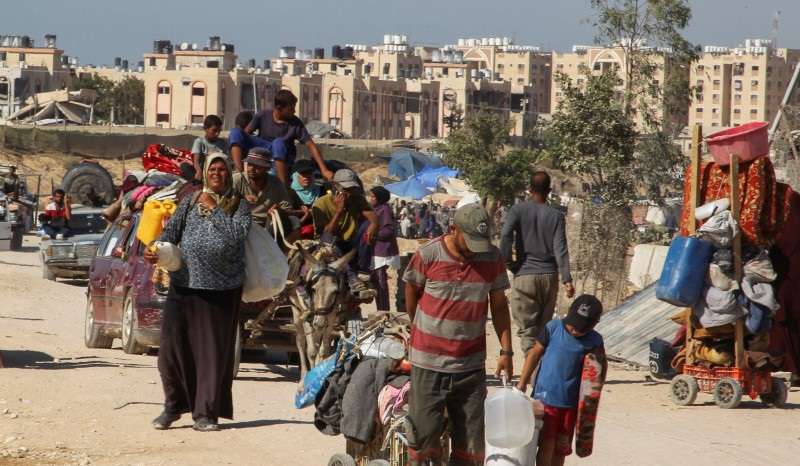 Displaced Palestinians make their way, as they flee Hamad City following an Israeli evacuation order, in Khan Younis