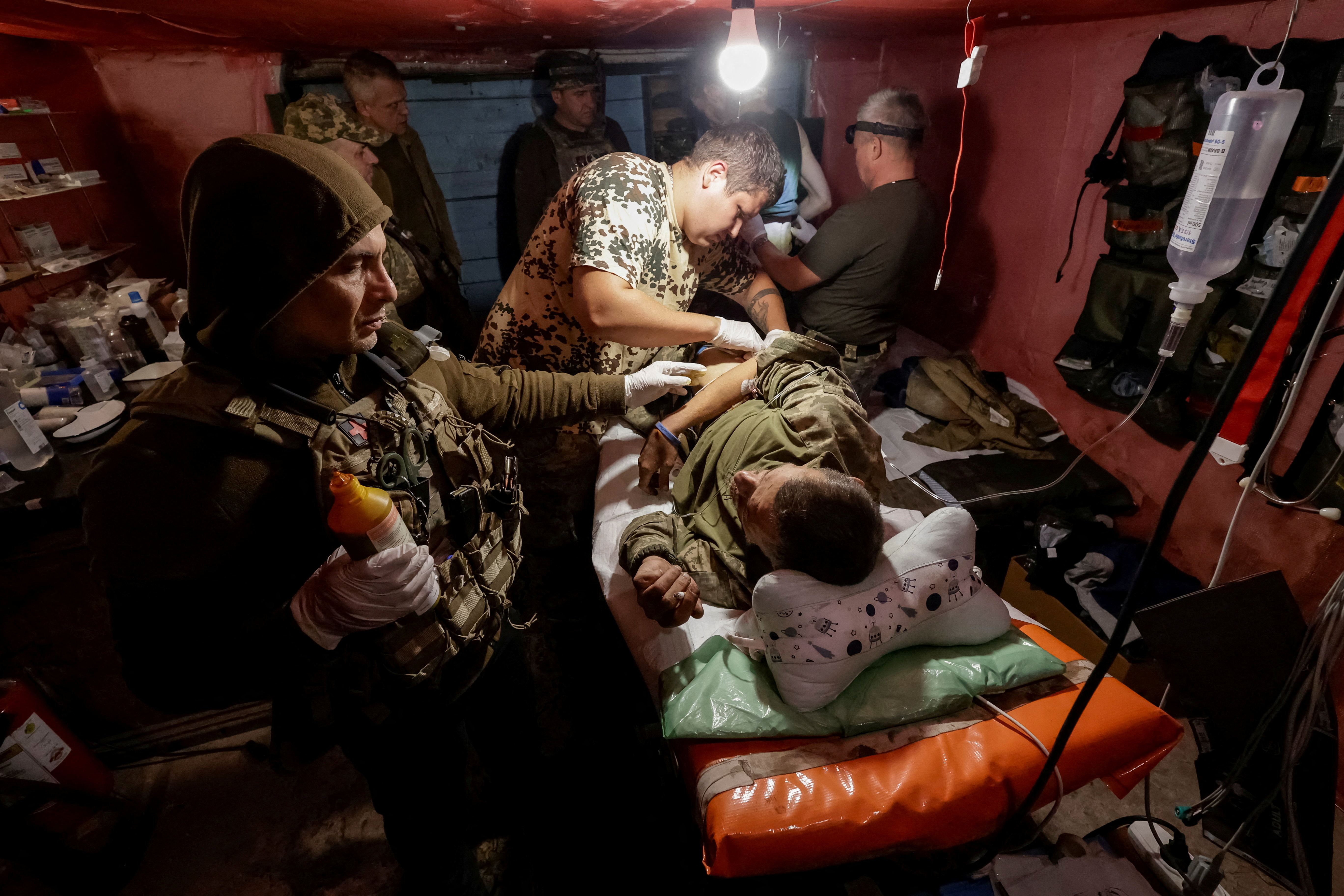 FILE PHOTO: Ukrainian servicemen bring their injured brothers-in-arm to a medical stabilisation point near a front line in Donetsk region