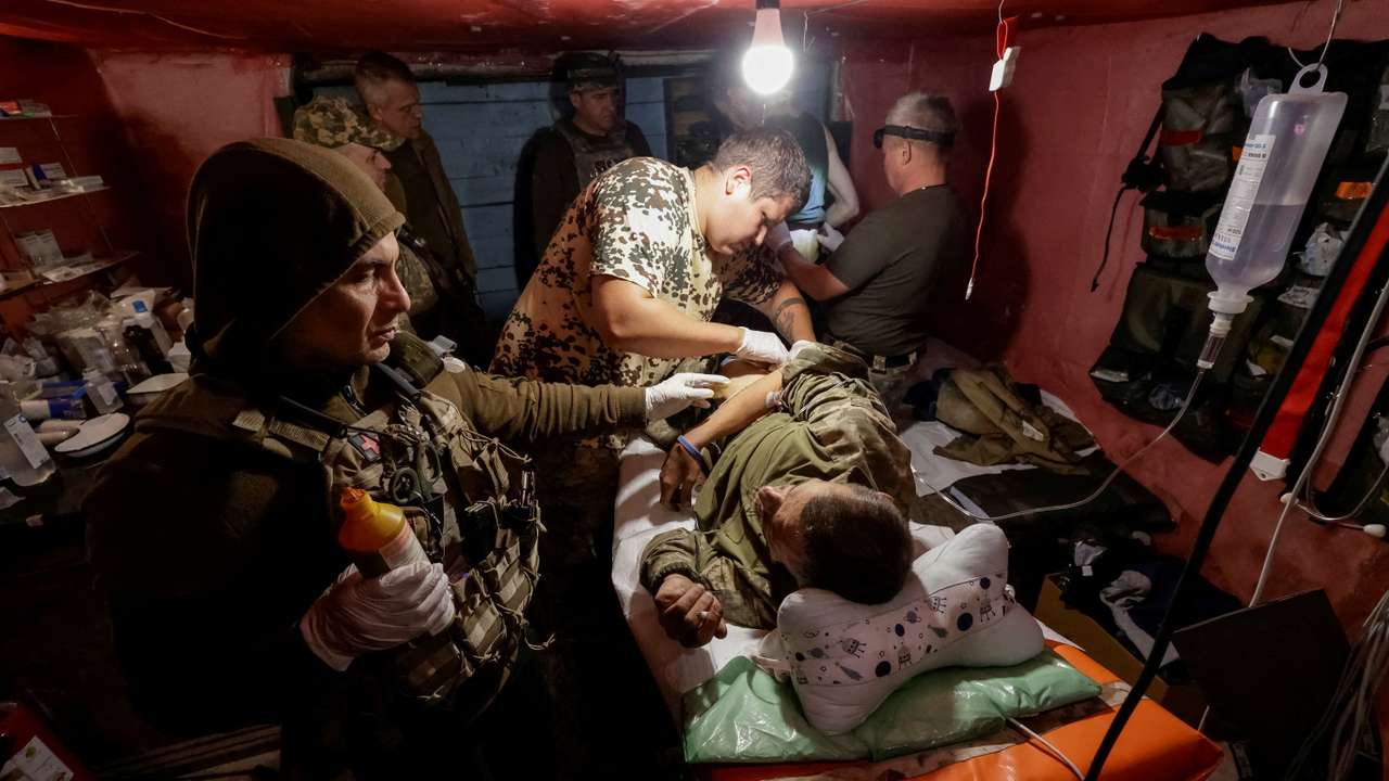 FILE PHOTO: Ukrainian servicemen bring their injured brothers-in-arm to a medical stabilisation point near a front line in Donetsk region