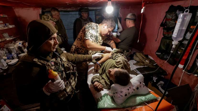 FILE PHOTO: Ukrainian servicemen bring their injured brothers-in-arm to a medical stabilisation point near a front line in Donetsk region