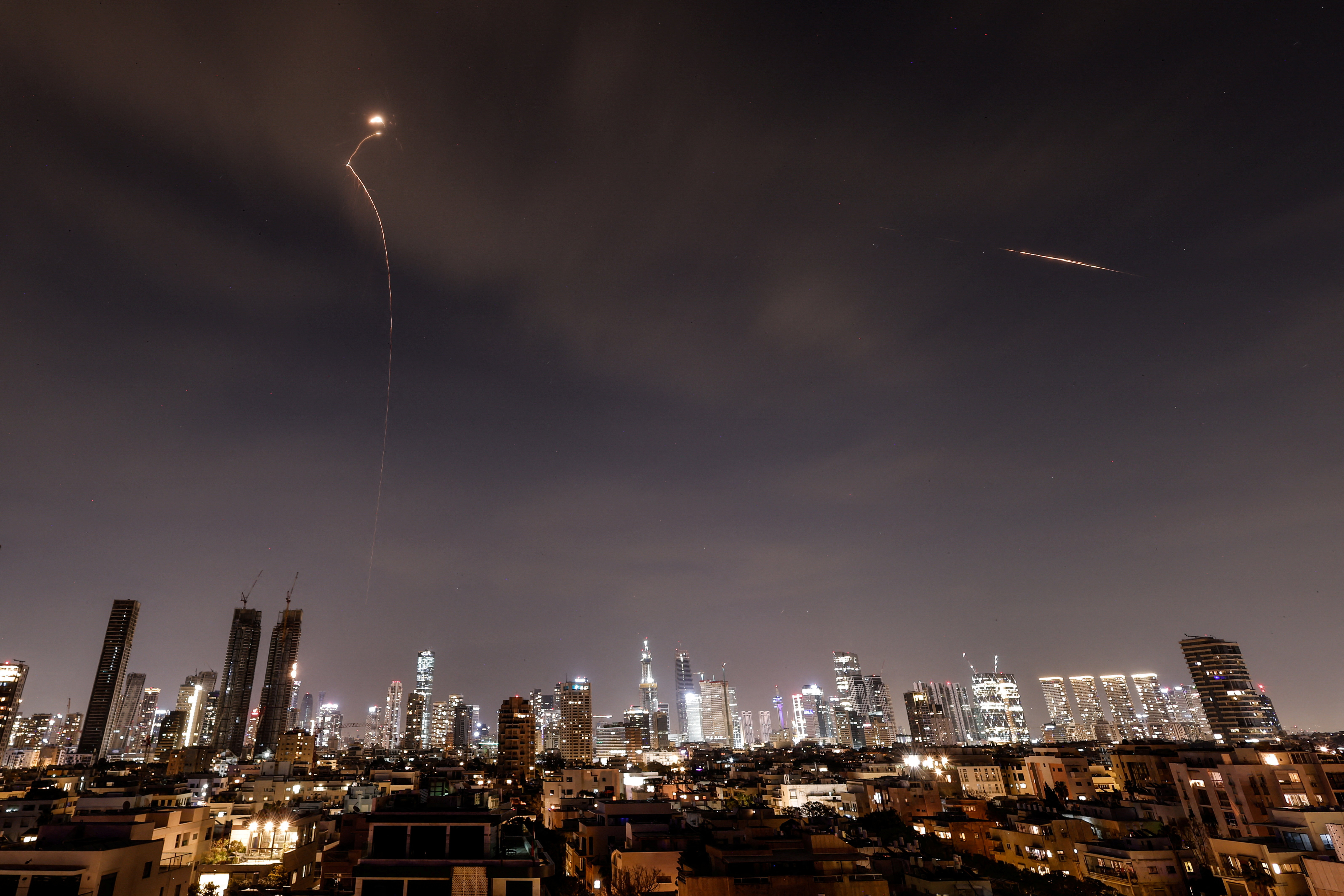 Streaks of light illuminate the sky during an interception attempt amid the U.S.-Israeli conflict with Iran, as seen from Tel Aviv
