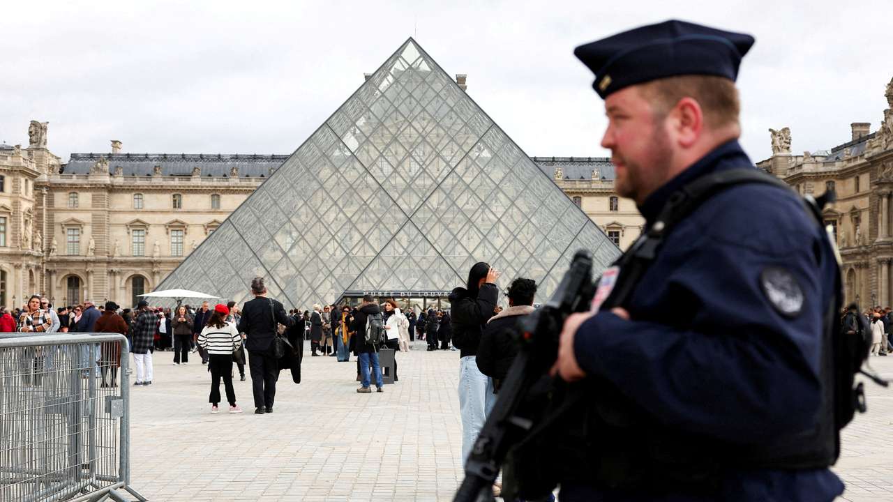FILE PHOTO: A French CRS riot police officer patrols near the glass Pyramid of the Louvre Museum