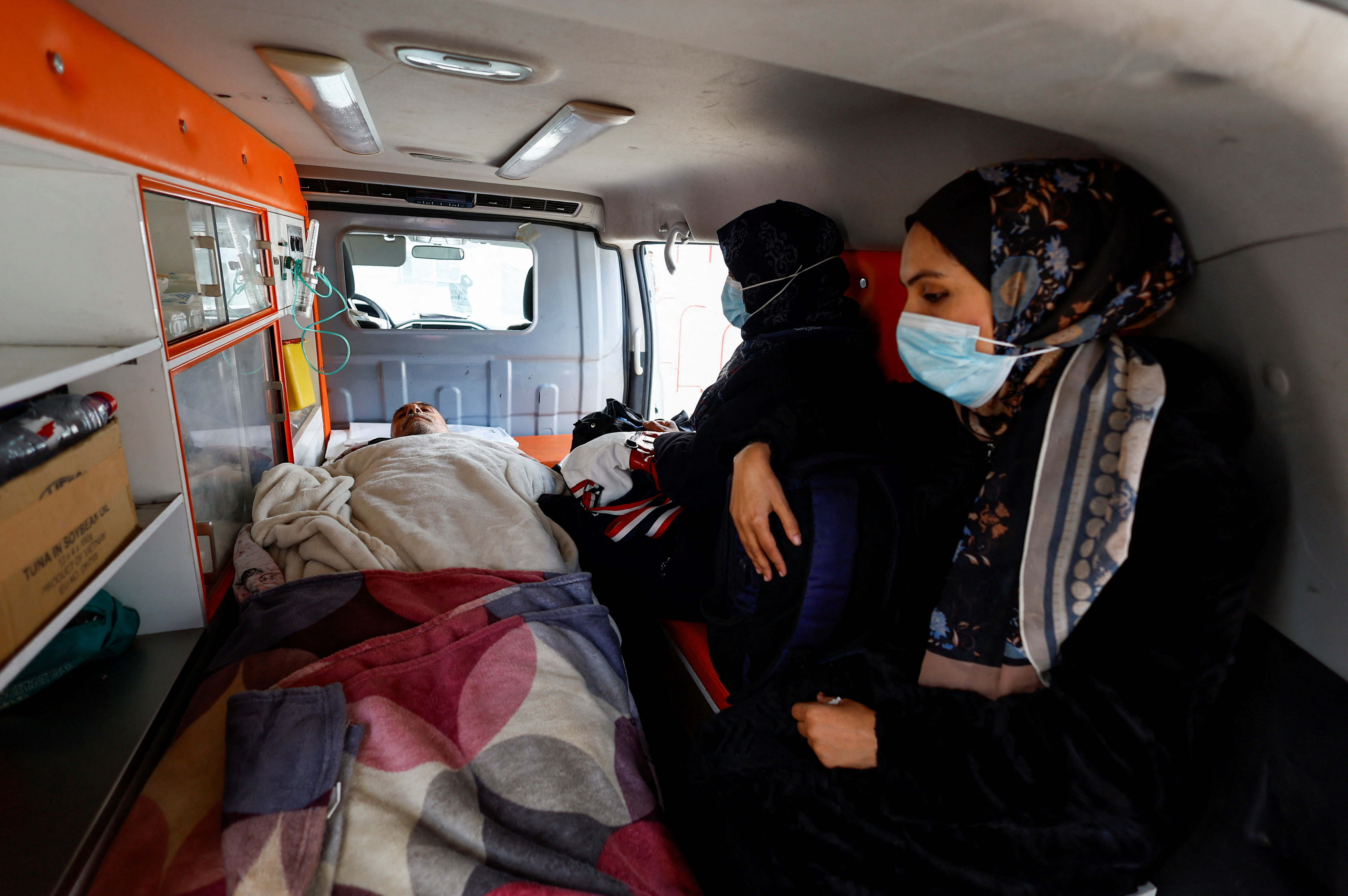 Palestinian patients, accompanied by relatives, make their way back to their homes in Khan Younis