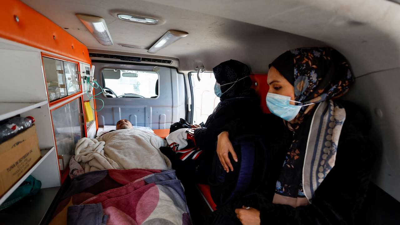 Palestinian patients, accompanied by relatives, make their way back to their homes in Khan Younis
