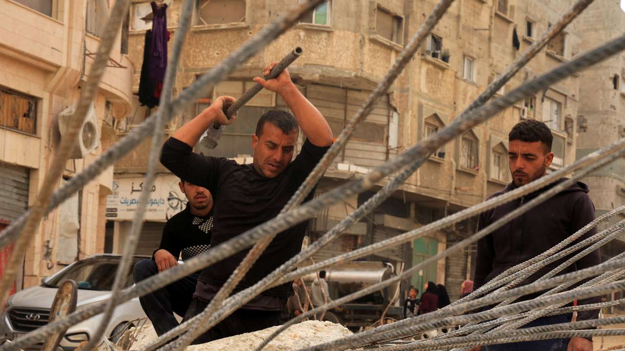 Palestinian workers break concrete to extract steel bars from destroyed homes, relying only on simple hand tools amid a severe shortage of construction materials caused by long-standing restrictions on the entry of cement and iron, in Khan Younis