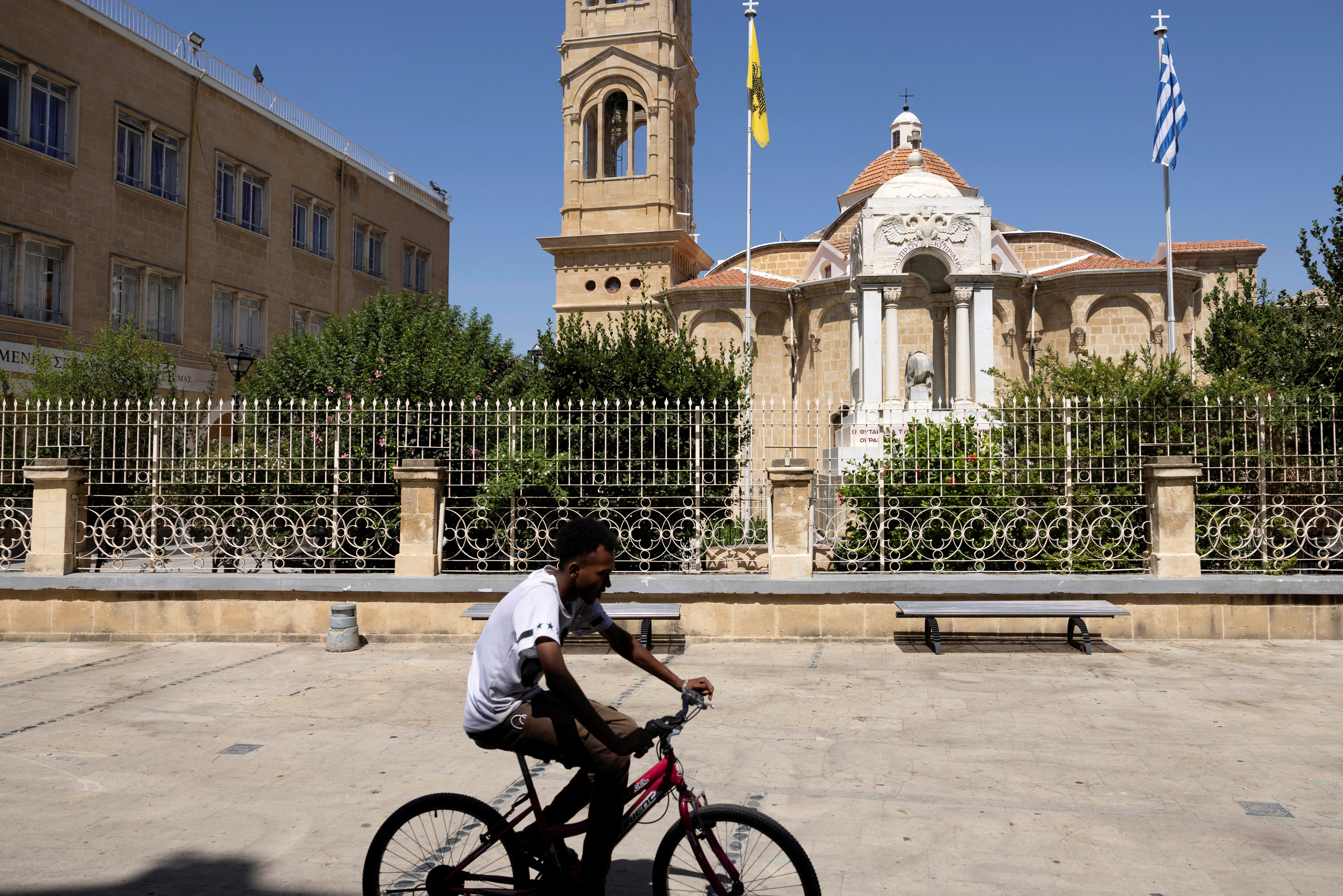 A man rides his bicycle outside the Panagia Faneromeni church in Nicosia