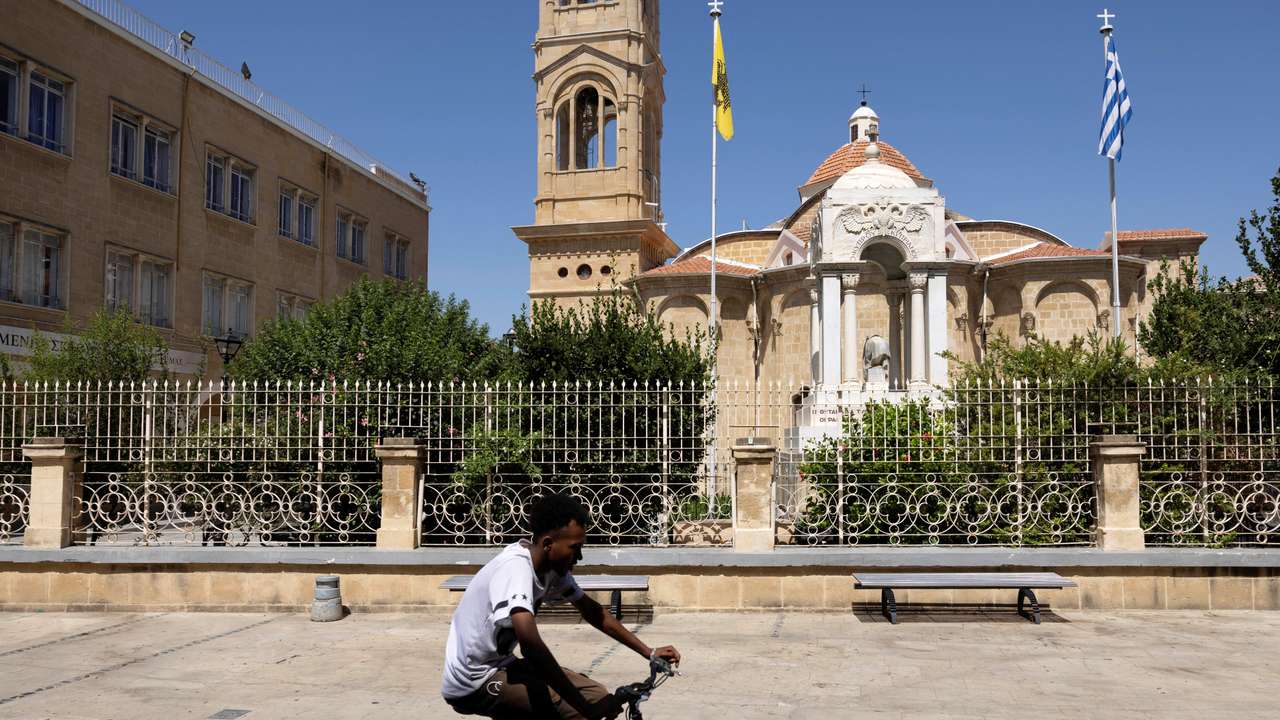 A man rides his bicycle outside the Panagia Faneromeni church in Nicosia