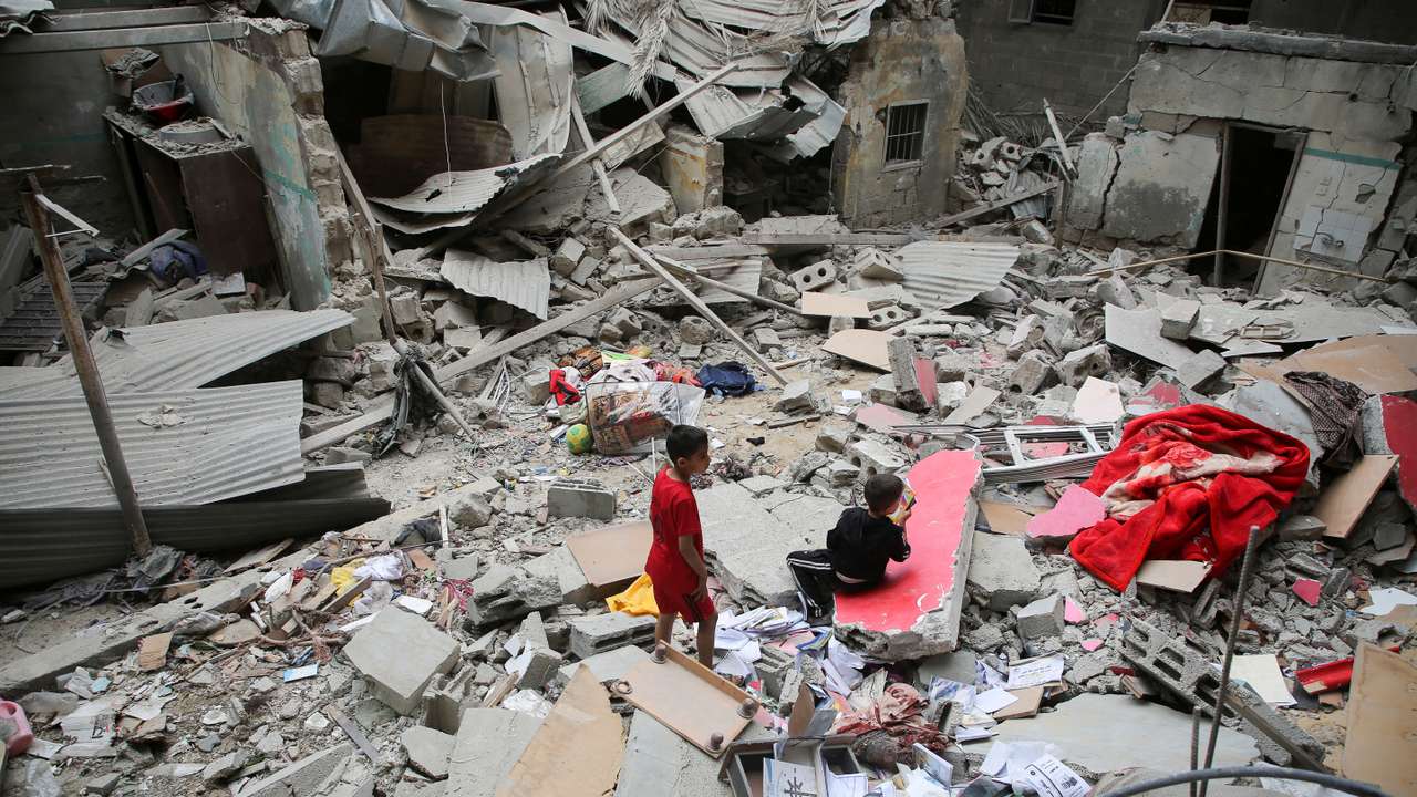 Palestinian children inspect the site of an Israeli strike on a house, in Rafah