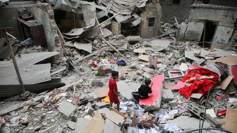 Palestinian children inspect the site of an Israeli strike on a house, in Rafah