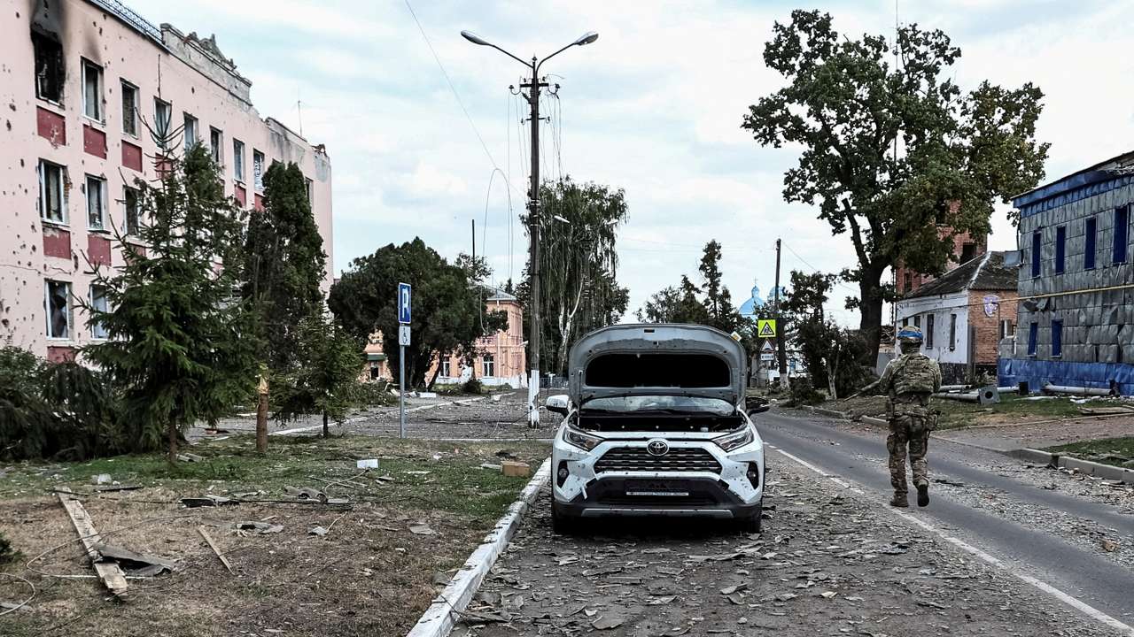 FILE PHOTO: A Ukrainian serviceman patrols a street next to damaged buildings in the town of Sudzha