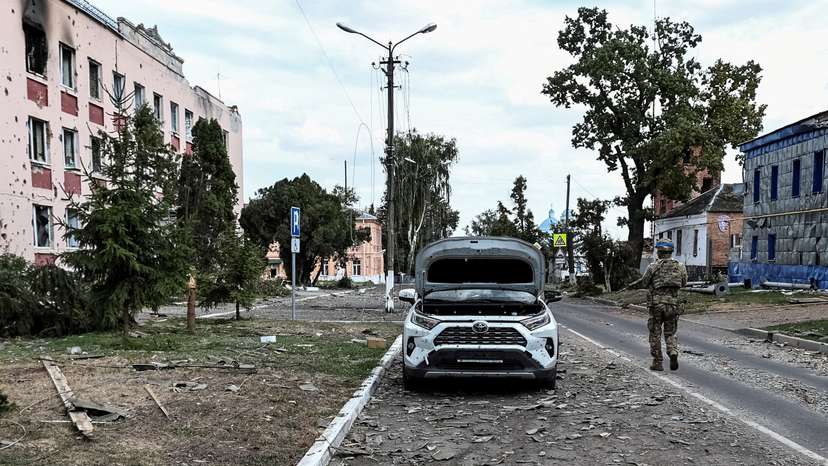 FILE PHOTO: A Ukrainian serviceman patrols a street next to damaged buildings in the town of Sudzha