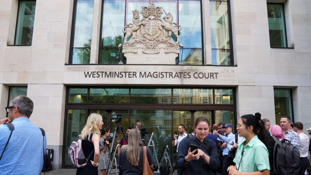 Members of the media wait outside Westminster Magistrates' Court