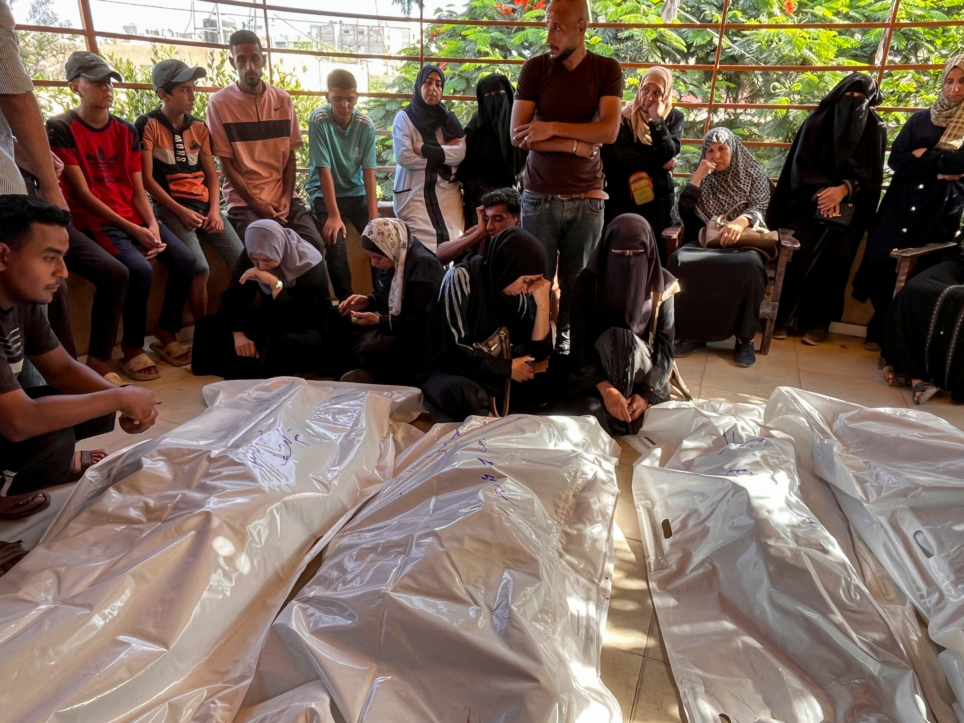 Mourners grieve next to the bodies of Palestinians killed in Israeli strikes, amid the Israel-Hamas conflict, at Nasser hospital in Khan Younis in the southern Gaza Strip
