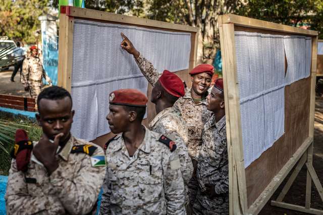 Members of the Djiboutian army react as they check the voters� roll before casting their ballots at a primary school serving as a polling station in Djibouti, on April 10, 2026, during the 2026 Djiboutian presidential elections. (Photo by Luis TATO / AFP)