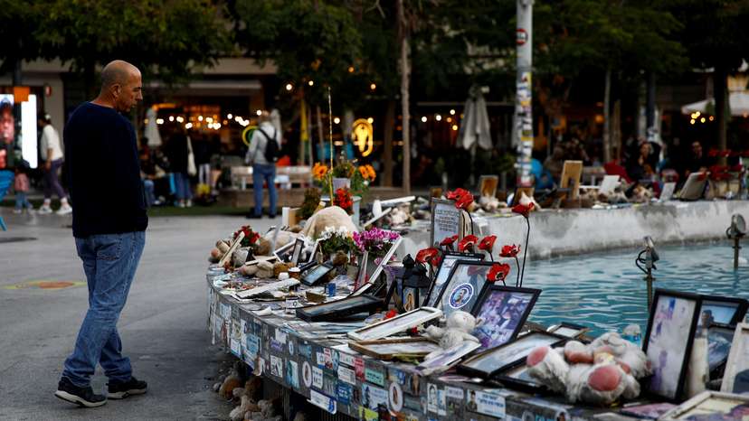 Man looks at pictures and memorabilia related to fallen soldiers, hostages and people killed during the October 7, 2023 attack, in Tel Aviv