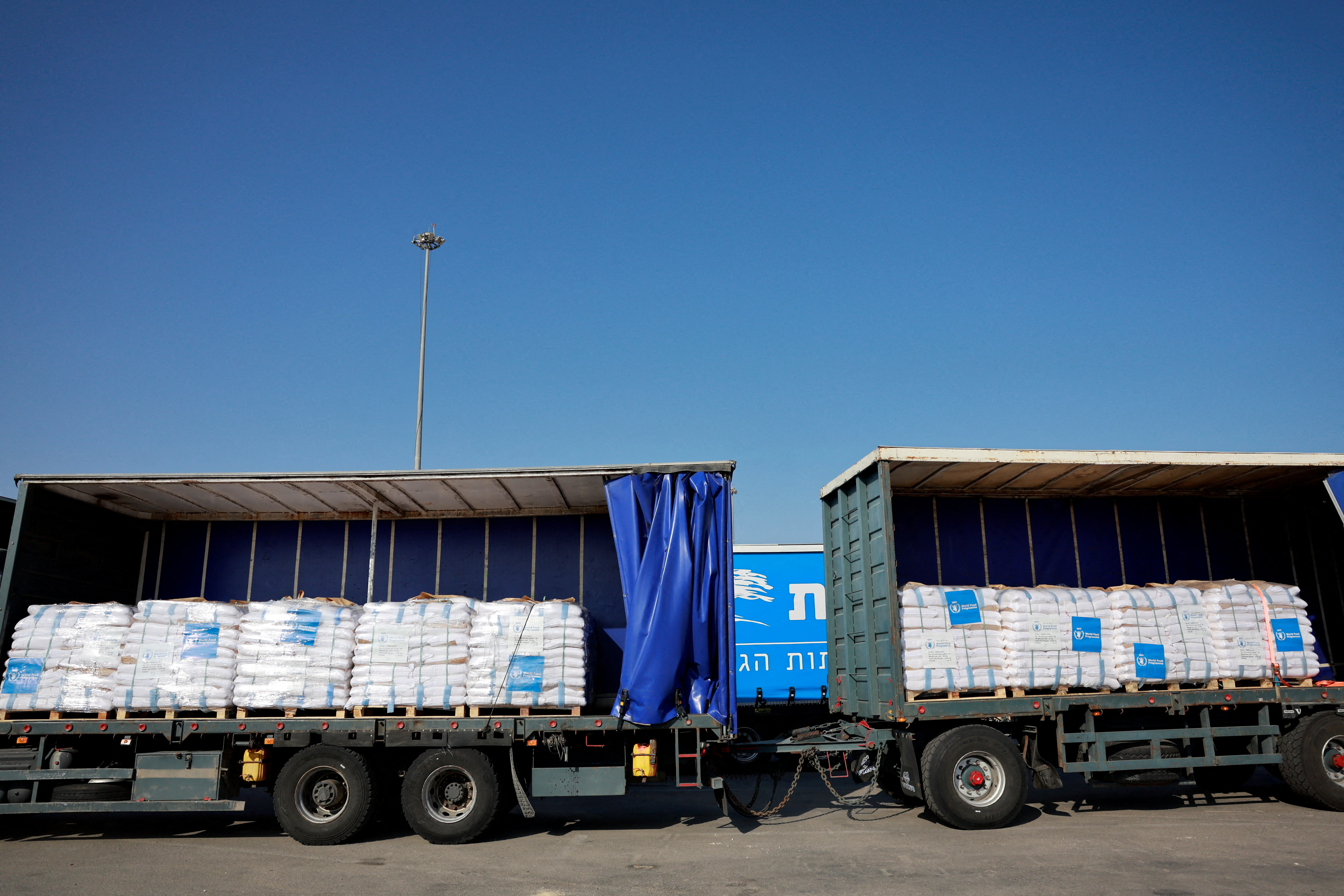 FILE PHOTO: Trucks carrying aid line up at the Kerem Shalom crossing between Israel and Gaza, before going into Gaza, on the Israeli side of the Israel-Gaza border