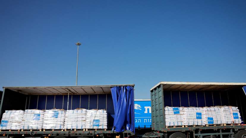 FILE PHOTO: Trucks carrying aid line up at the Kerem Shalom crossing between Israel and Gaza, before going into Gaza, on the Israeli side of the Israel-Gaza border
