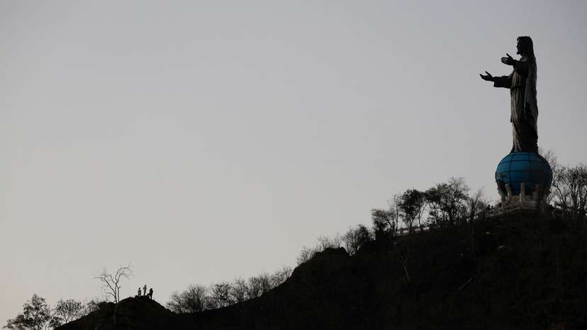 People stand on the hill near Cristo Rei, a statue depicting Jesus Christ, in Dili