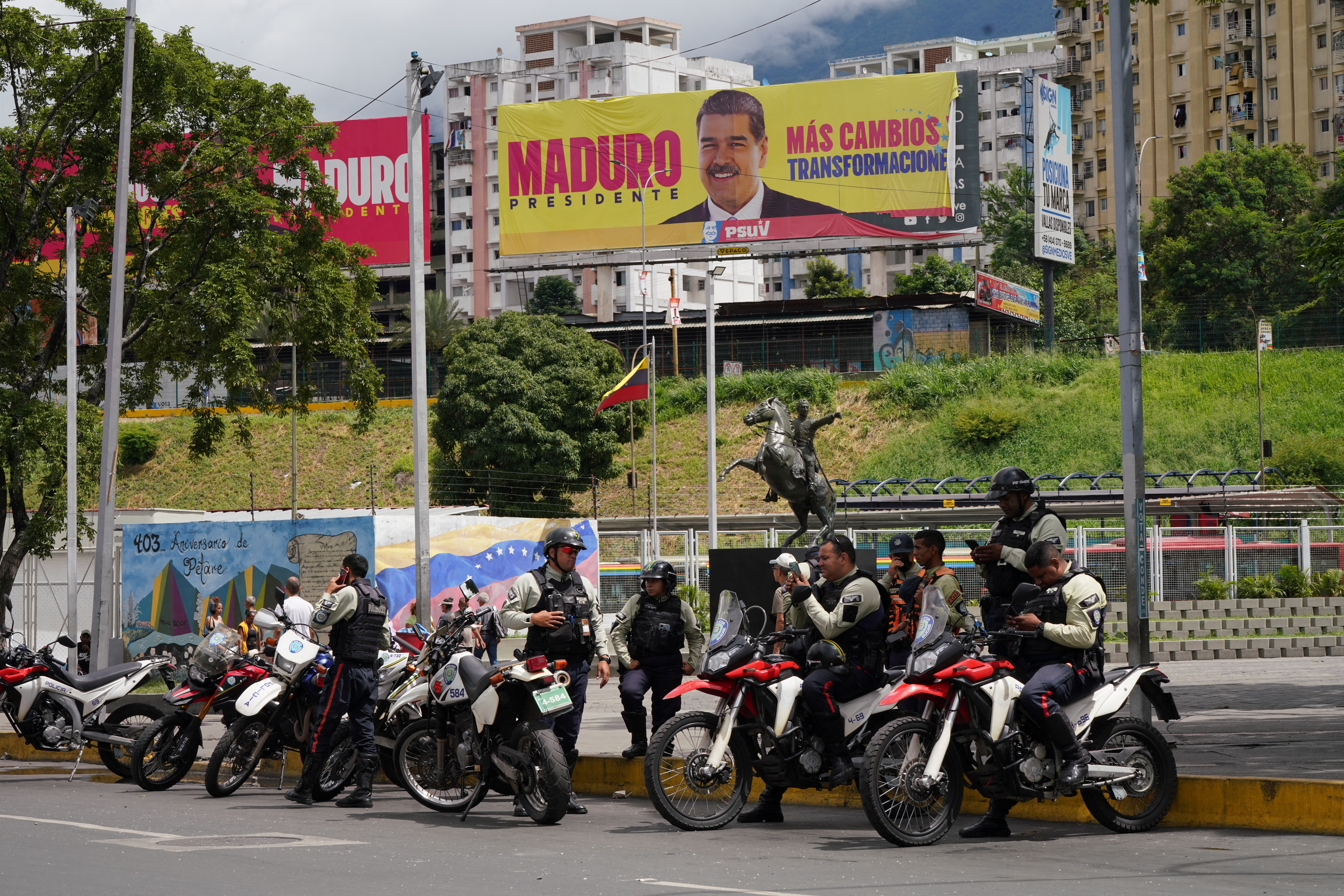 Police officers stand near image of Venezuela's President Maduro, in Caracas