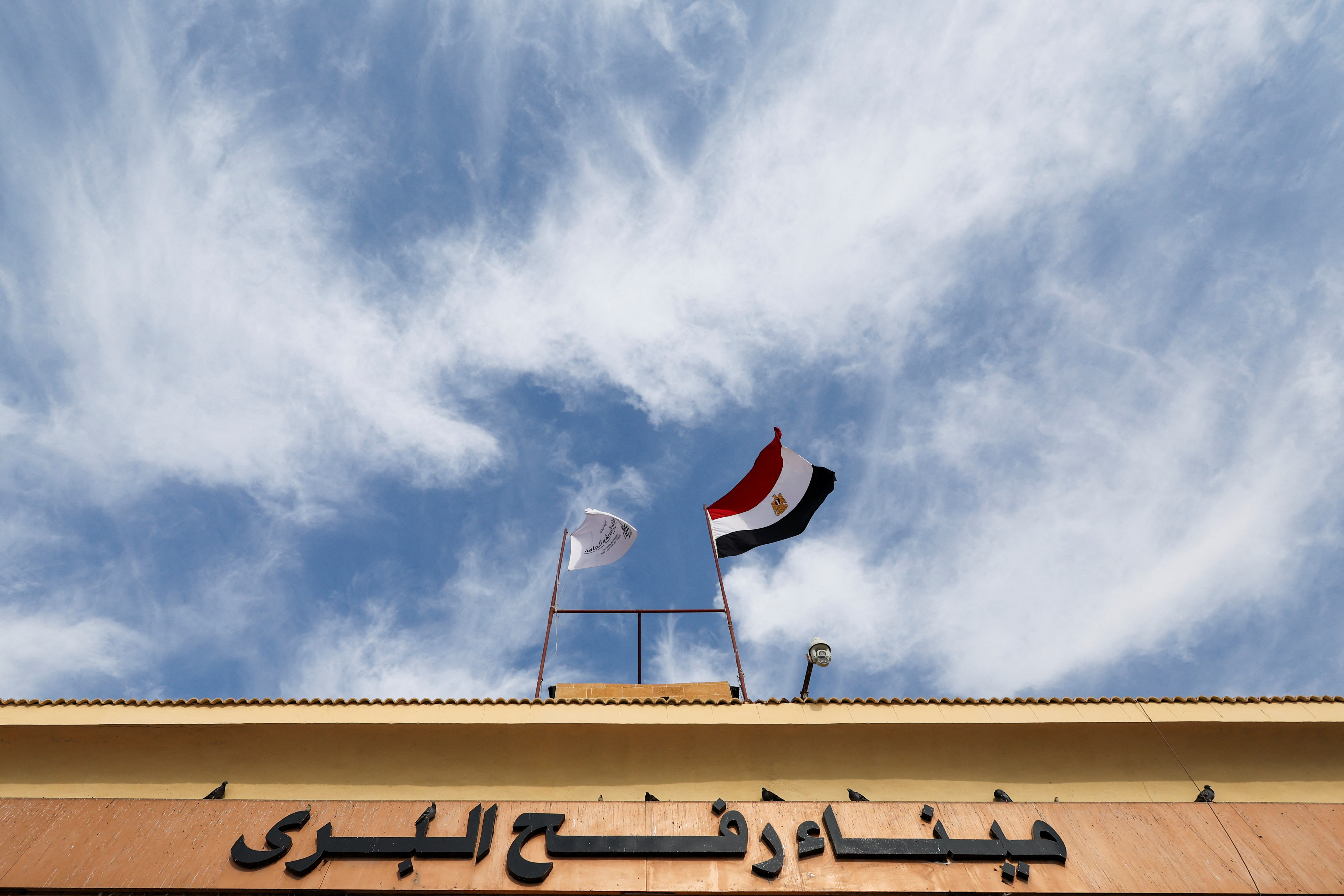 Egyptian flag waves on a gate at the Rafah border crossing