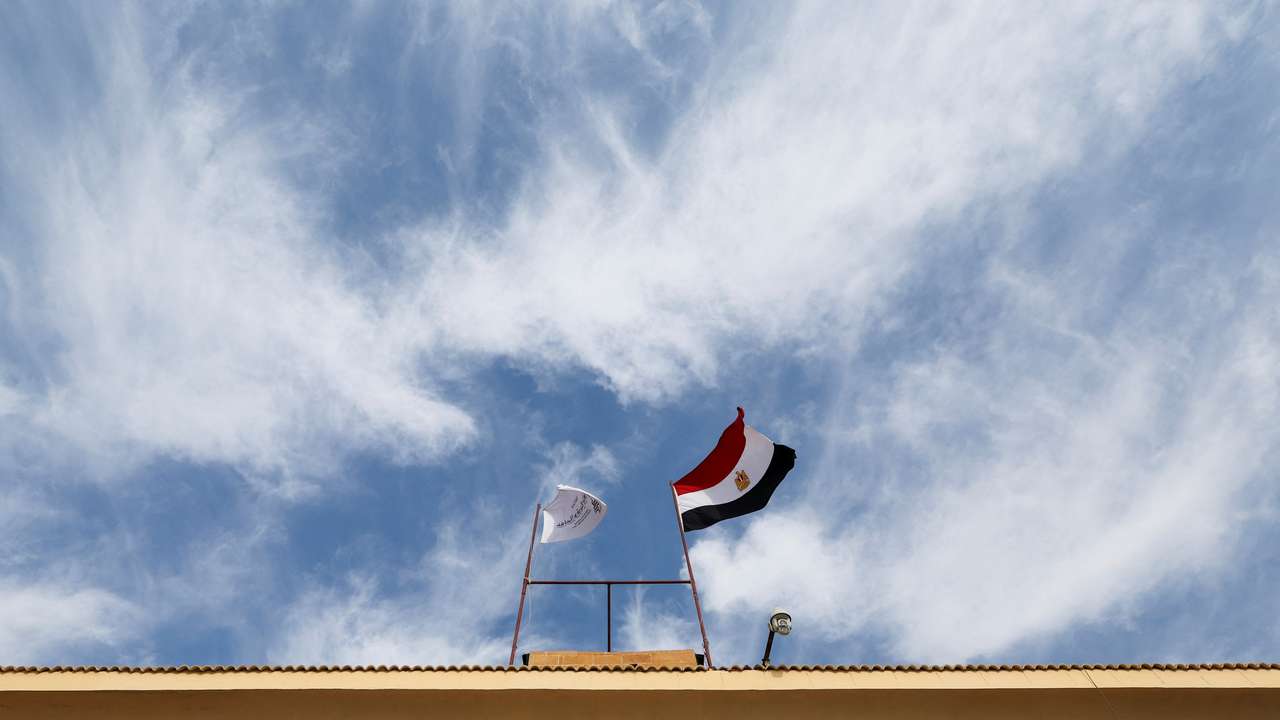 Egyptian flag waves on a gate at the Rafah border crossing