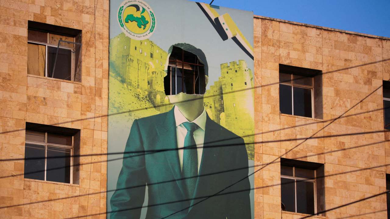 FILE PHOTO: A view shows a damaged poster of Syria's President Bashar al-Assad in Aleppo