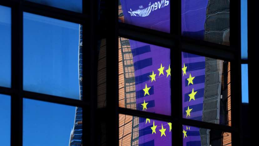 A banner depicting an European Union flag is reflected in a window outside the EU Council headquarters in Brussels