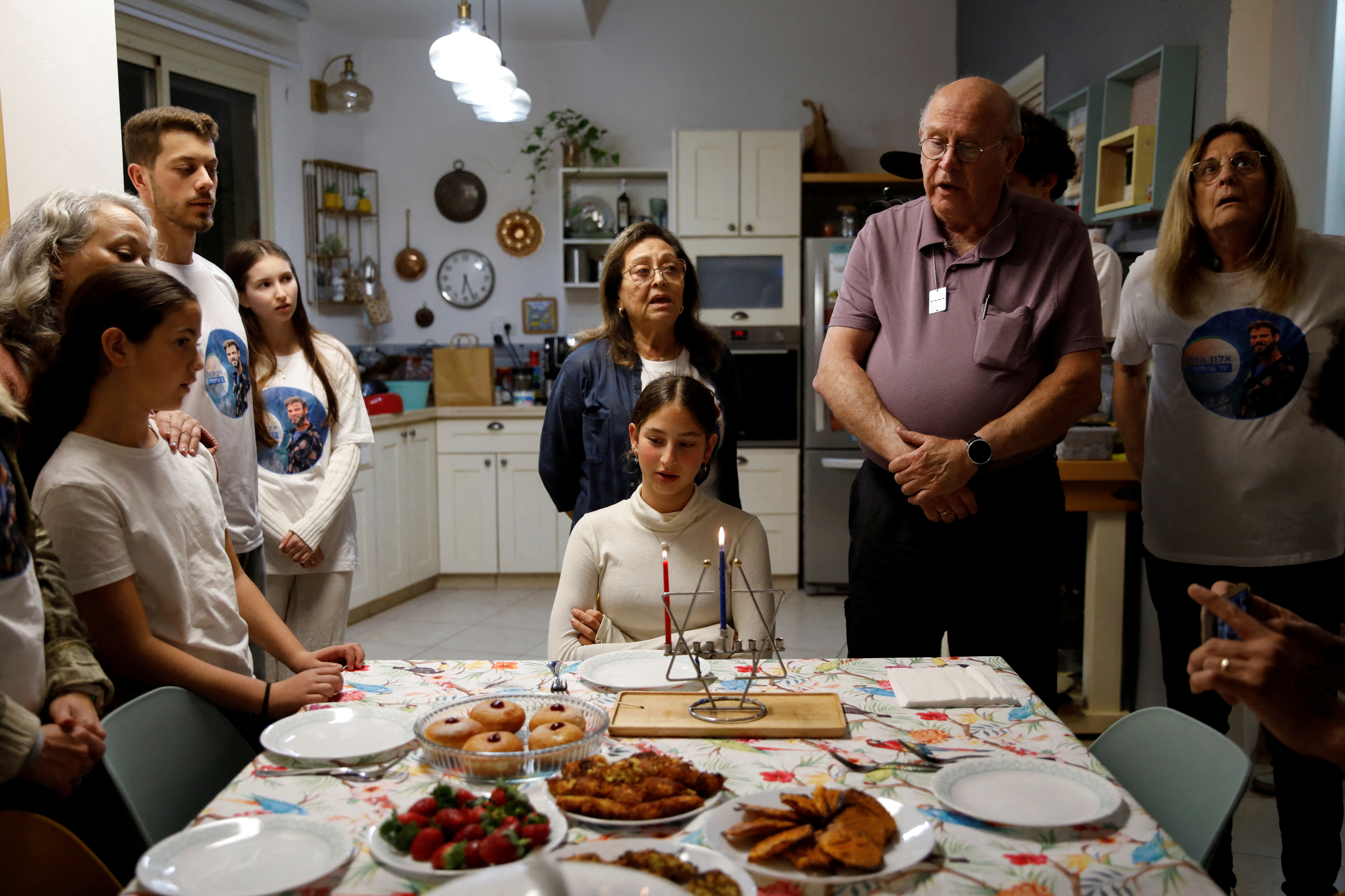 Family of Alon Ohel light the first candle to mark the first night of the Jewish holiday of Hanukkah in their house in Levon