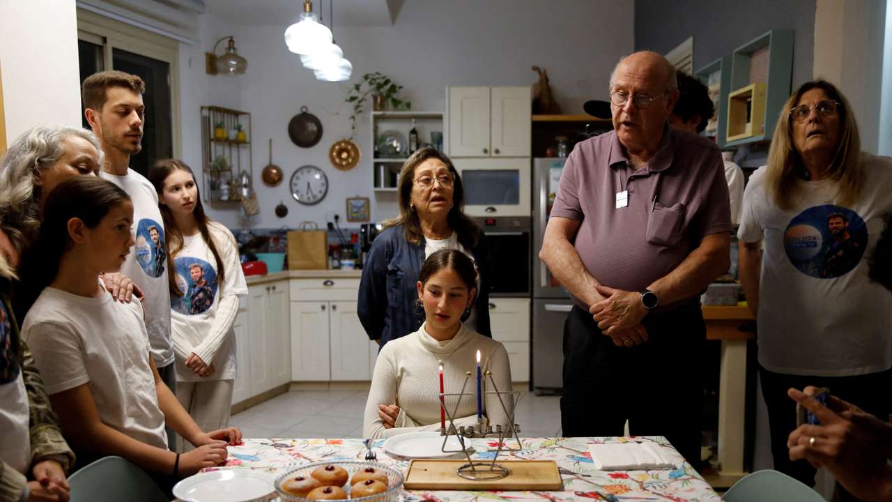 Family of Alon Ohel light the first candle to mark the first night of the Jewish holiday of Hanukkah in their house in Levon